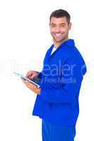 Happy male mechanic using tablet computer