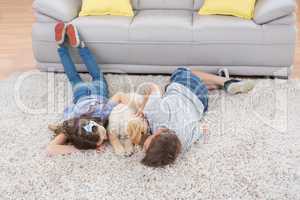 Siblings with dog lying on rug