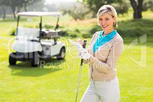 Cheerful golfer standing on the putting green