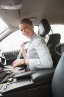 Businesswoman putting on her seat belt