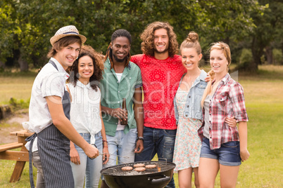 Happy friends in the park having barbecue