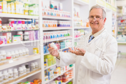Smiling senior pharmacist showing medication