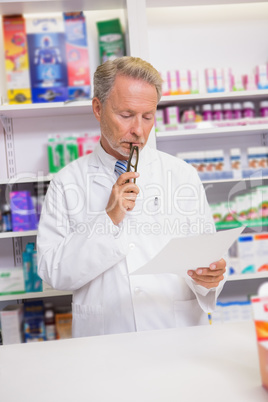 Serious senior pharmacist reading prescription