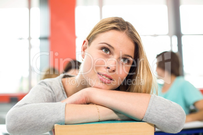 Thoughtful student with books in classroom