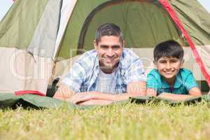 Father and son lying beside their tent