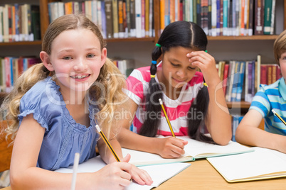 Cute pupils drawing in library