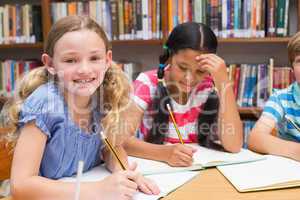 Cute pupils drawing in library