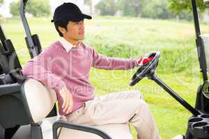 Golfer driving his golf buggy