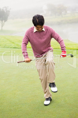 Angry golfer trying to brake his club