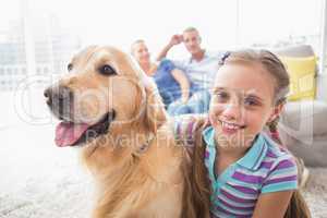 Girl with dog while parents relaxing at home