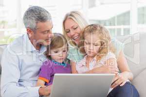 Parents using laptop with children