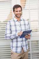 Happy man smiling at camera holding tablet