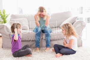 Upset woman sitting on sofa while brother teasing sister
