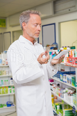 Pharmacist reading prescription and holding medicine