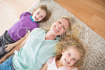 Happy mother and children lying on rug