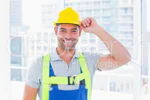Happy manual worker wearing yellow hard hat