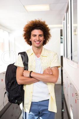 Young man with arms crossed in office corridor