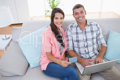 Couple shopping online using laptop and credit card