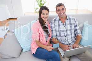 Couple shopping online using laptop and credit card