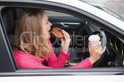Young woman having coffee and doughnut