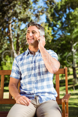 Man sitting on park bench with phone