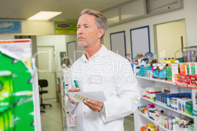 Senior pharmacist holding prescription and medicines