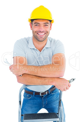 Handyman with hand tools on step ladder
