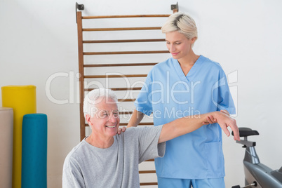 Senior man stretching with his therapist