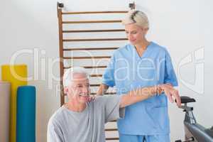 Senior man stretching with his therapist