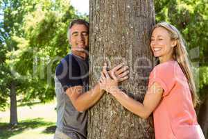 Happy couple hugging a tree