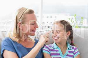 Mother touching daughter in living room