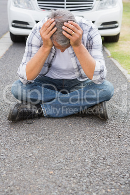 Stressed man sitting on the ground