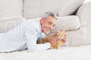 Happy man with dog lying on rug