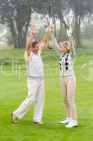 Excited golfing couple cheering