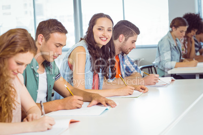 Fashion student smiling at camera in class