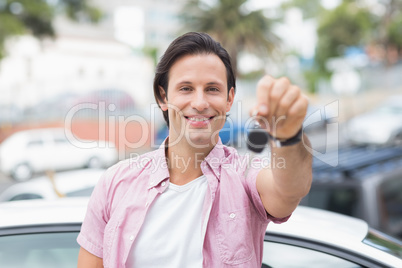 Young man smiling and holding key