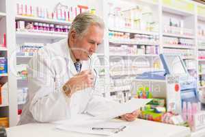 Senior pharmacist reading prescription