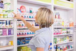 Blonde customer pointing medicine from shelf