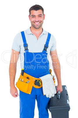 Happy workman in overalls holding toolbox
