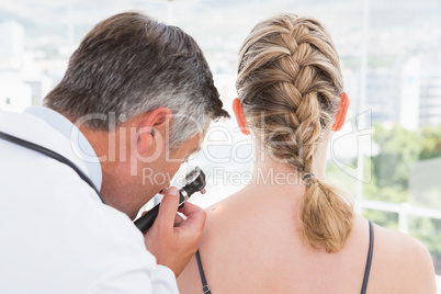 Doctor examining a spot at his patient Doctor examining a spot at his patient