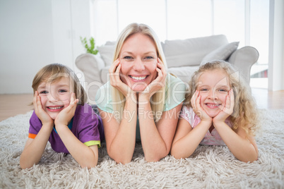 Mother and children with head in hands lying on rug