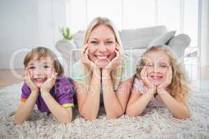 Mother and children with head in hands lying on rug