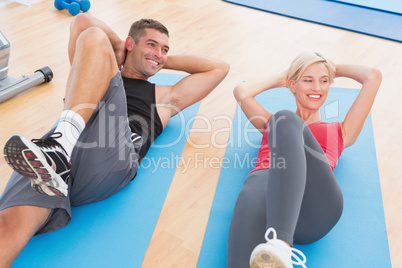 Happy fit couple working on exercise mat