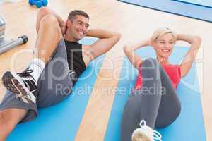 Happy fit couple working on exercise mat