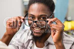 Happy male fashion designer holding eye glasses
