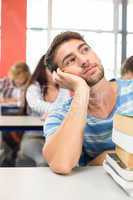 Thoughtful student with books in classroom