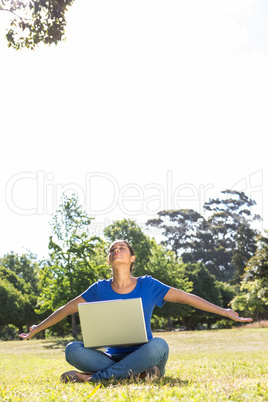Carefree woman using laptop in park