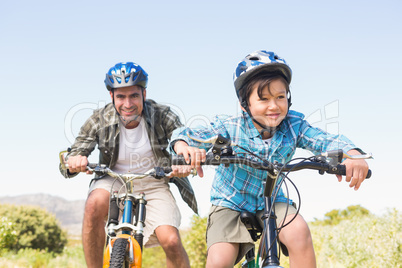 Father and son biking through mountains