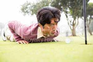 Golfer trying to flick ball into hole