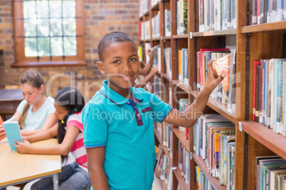 Cute pupil looking for books in library